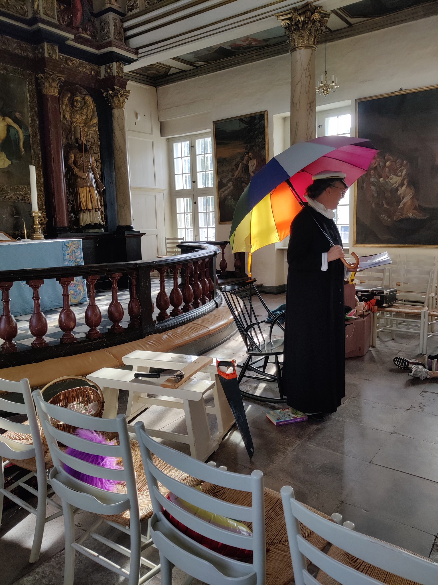 Sognepræst Hanne Beierholm Christensen til familiegudstjeneste iført matros kasket og paraply