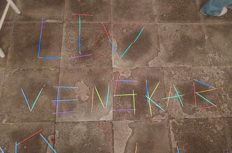 Liv og venskab skrevet med knæklys på kirkegulvet