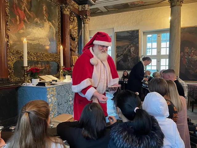Julemanden hjælper præsten med uddeling af nadver